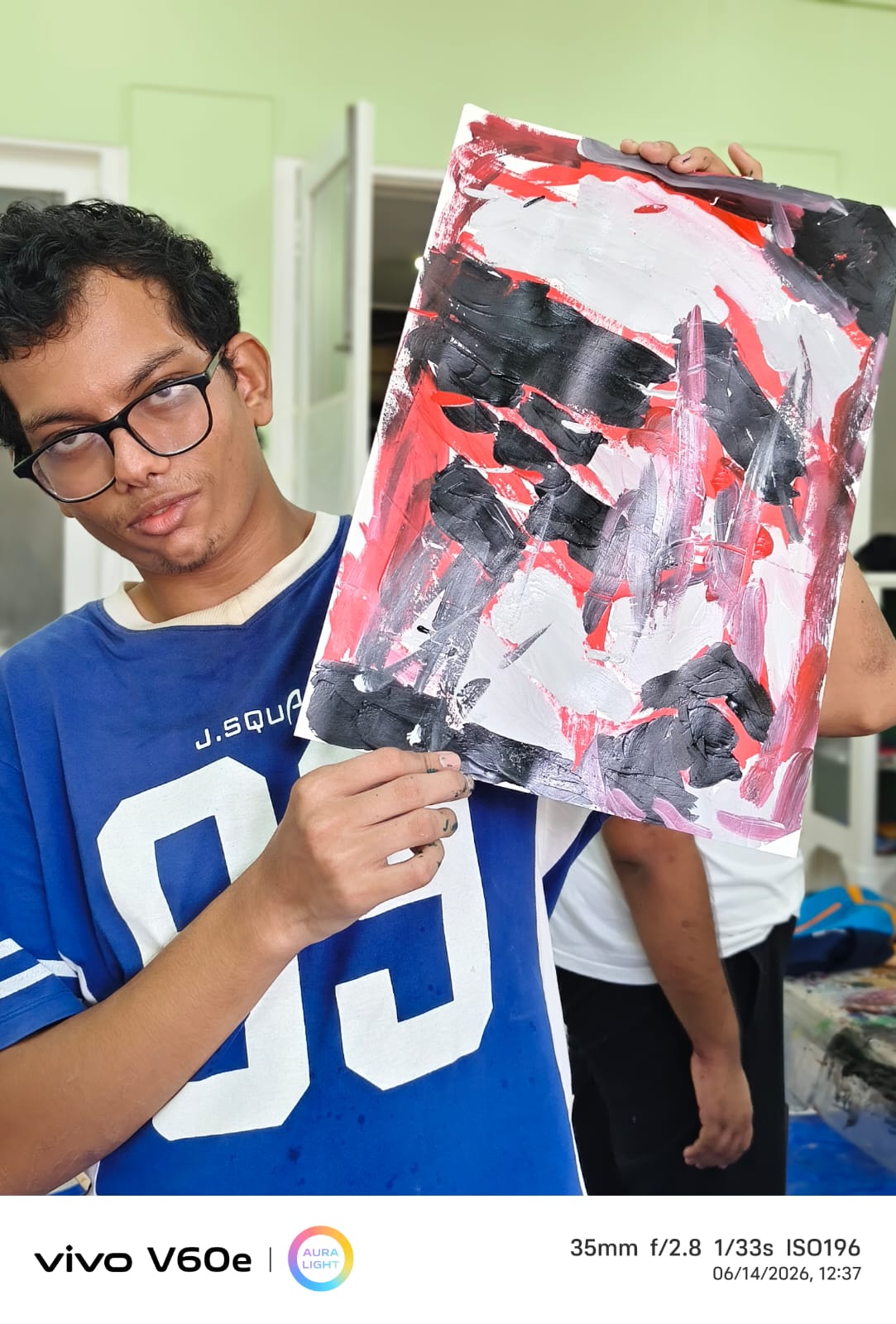 Alma Studio artist holding up his finished abstract painting