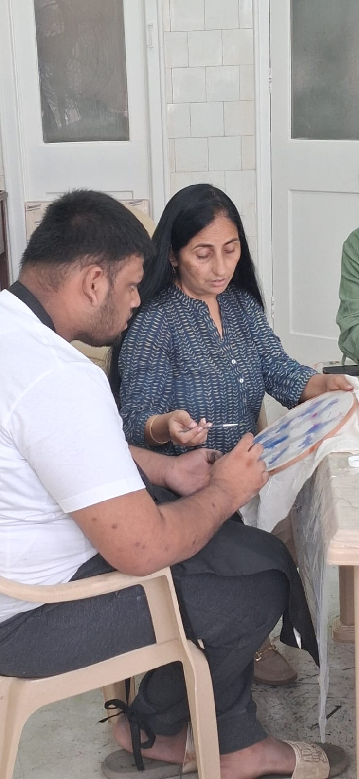 Alma Studio artist and mentor working together on an embroidery hoop